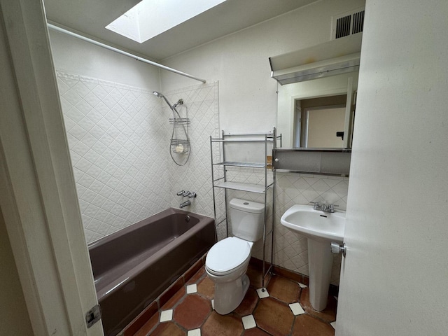 6488 Tahawash St, Cochiti Lake, NM 87083 - bathroom featuring tile walls, visible vents, a skylight, toilet, and shower / bathing tub combination