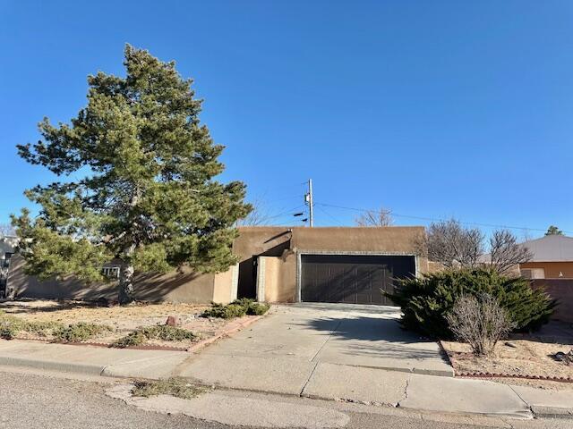 701 Houston Ave, Grants, NM 87020 - view of front facade featuring stucco siding, a garage, and concrete driveway