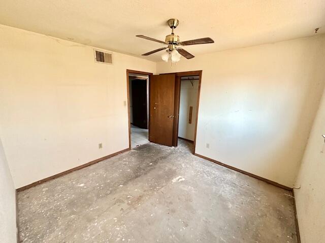 701 Houston Ave, Grants, NM 87020 - unfurnished room featuring baseboards, unfinished concrete flooring, visible vents, and a ceiling fan