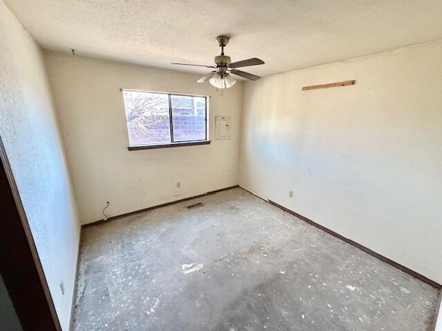 701 Houston Ave, Grants, NM 87020 - empty room featuring unfinished concrete floors, visible vents, ceiling fan, and a textured ceiling