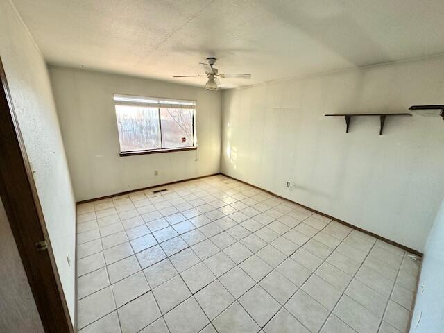 701 Houston Ave, Grants, NM 87020 - unfurnished bedroom featuring a ceiling fan, visible vents, and light tile patterned floors