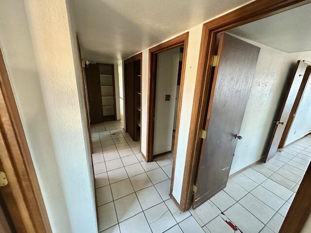 701 Houston Ave, Grants, NM 87020 - hallway featuring light tile patterned flooring and a textured wall
