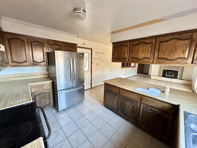 701 Houston Ave, Grants, NM 87020 - kitchen featuring light countertops, electric range, light tile patterned floors, and freestanding refrigerator