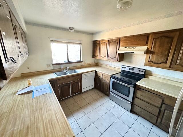 701 Houston Ave, Grants, NM 87020 - kitchen featuring light countertops, stainless steel electric range oven, dishwasher, under cabinet range hood, and a sink