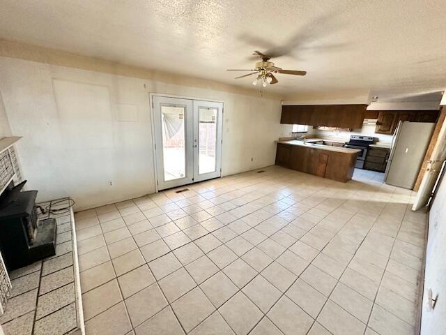 701 Houston Ave, Grants, NM 87020 - kitchen with light countertops, french doors, a ceiling fan, stainless steel range with electric cooktop, and open floor plan