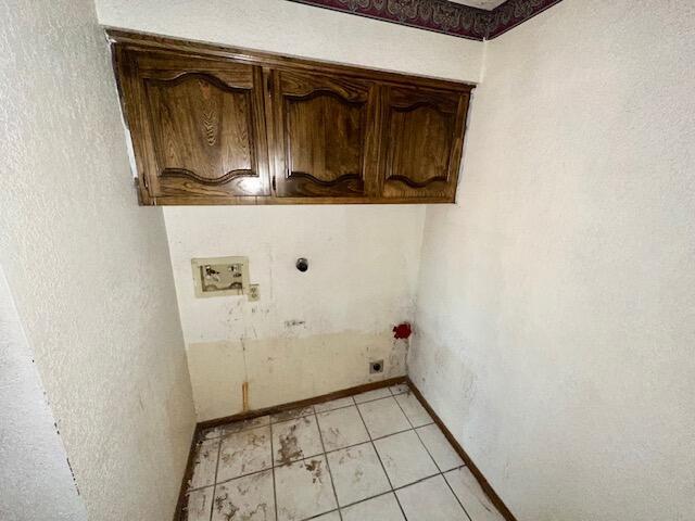 701 Houston Ave, Grants, NM 87020 - laundry room featuring light tile patterned floors, baseboards, cabinet space, electric dryer hookup, and washer hookup