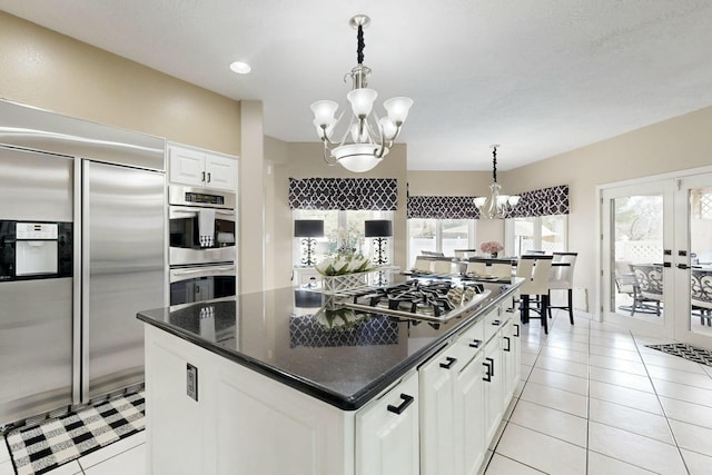 6404 Oak Hill NE, Albuquerque, NM 87111 - kitchen featuring white cabinetry, stainless steel appliances, a chandelier, and light tile patterned floors