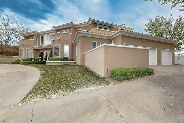 6404 Oak Hill NE, Albuquerque, NM 87111 - view of front of house with stucco siding, a garage, a tiled roof, and concrete driveway