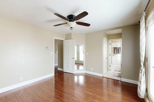 6404 Oak Hill NE, Albuquerque, NM 87111 - unfurnished bedroom featuring baseboards, wood finished floors, ceiling fan, and a textured ceiling