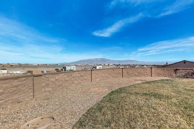view of yard with a fenced backyard and a mountain view