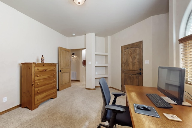 office space featuring baseboards, visible vents, and light carpet