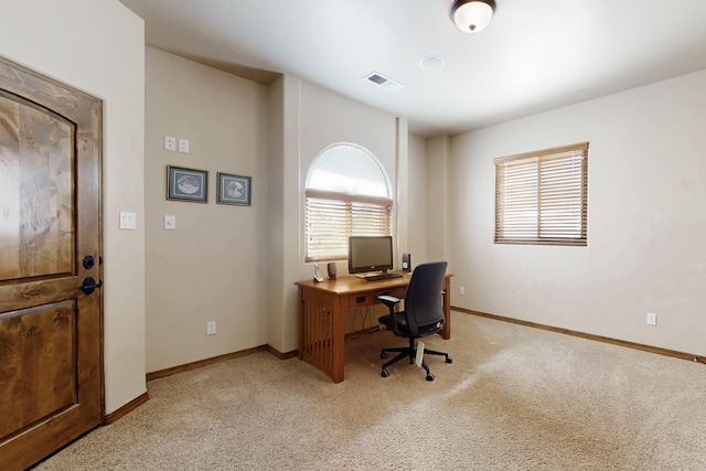 office area featuring light colored carpet, visible vents, and baseboards