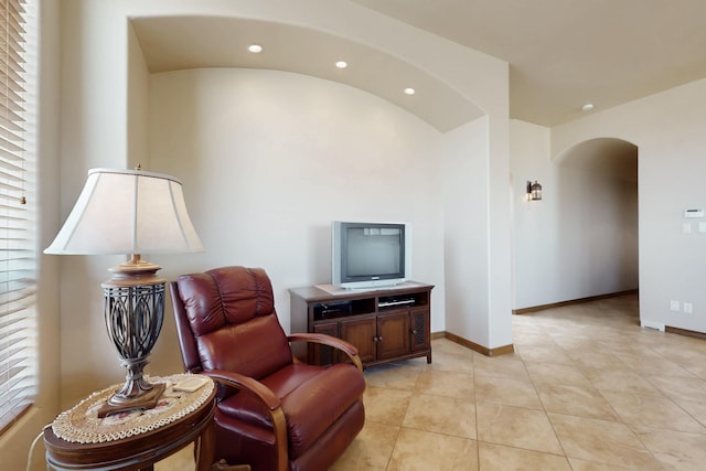 sitting room featuring baseboards, arched walkways, recessed lighting, and light tile patterned floors
