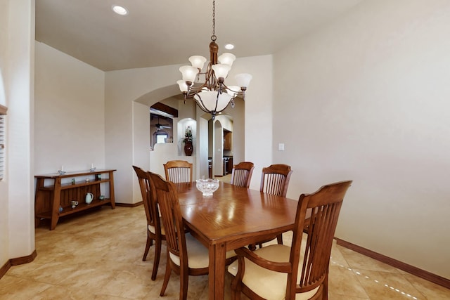 dining room featuring baseboards, a notable chandelier, arched walkways, and recessed lighting