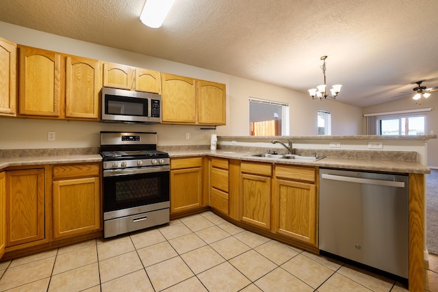 6331 Avenida Madrid NW, Albuquerque, NM 87114 - kitchen featuring a sink, light tile patterned floors, stainless steel appliances, decorative light fixtures, and a peninsula