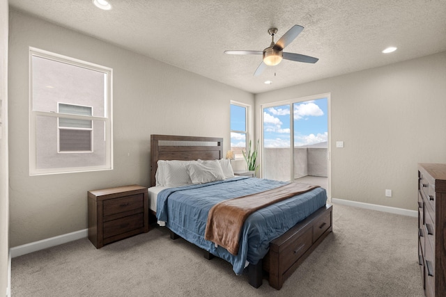 2422 Lynn Rd SE, Rio Rancho, NM 87124 - bedroom with access to outside, light carpet, a textured ceiling, a ceiling fan, and baseboards