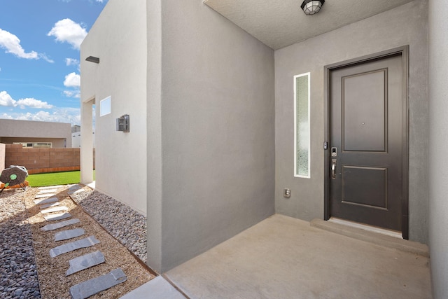 2422 Lynn Rd SE, Rio Rancho, NM 87124 - doorway to property with stucco siding, a patio area, and fence
