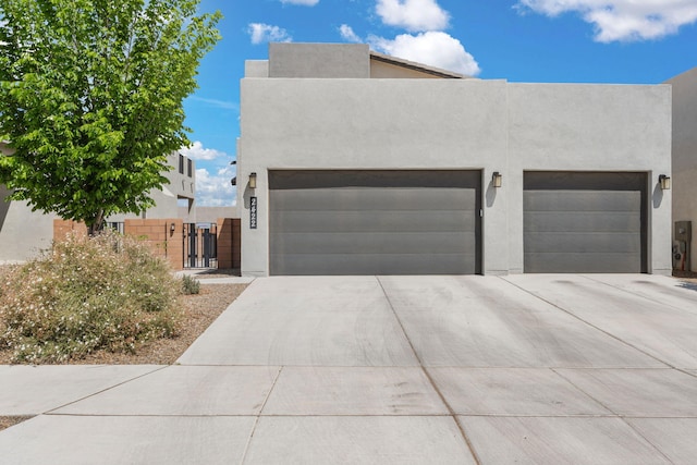 2422 Lynn Rd SE, Rio Rancho, NM 87124 - view of front of home featuring a garage, stucco siding, driveway, and a gate