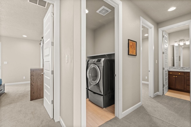 2422 Lynn Rd SE, Rio Rancho, NM 87124 - laundry area featuring baseboards, light colored carpet, washer / clothes dryer, and visible vents