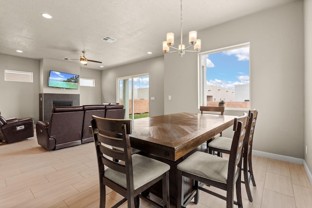 2422 Lynn Rd SE, Rio Rancho, NM 87124 - dining room featuring visible vents, a fireplace, baseboards, recessed lighting, and ceiling fan with notable chandelier
