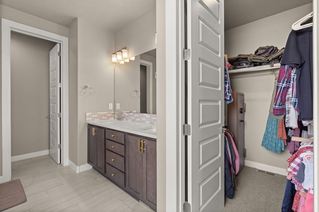 2422 Lynn Rd SE, Rio Rancho, NM 87124 - interior space featuring baseboards, visible vents, a walk in closet, and vanity