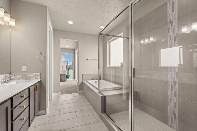 2422 Lynn Rd SE, Rio Rancho, NM 87124 - full bathroom featuring tile patterned flooring, vanity, a textured ceiling, a garden tub, and a stall shower