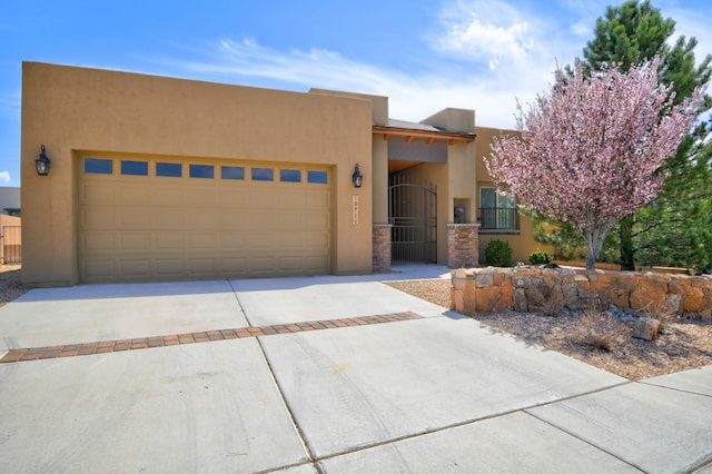 10916 Calandrias St NW, Albuquerque, NM 87114 - southwest-style home with a gate, stucco siding, a garage, and concrete driveway