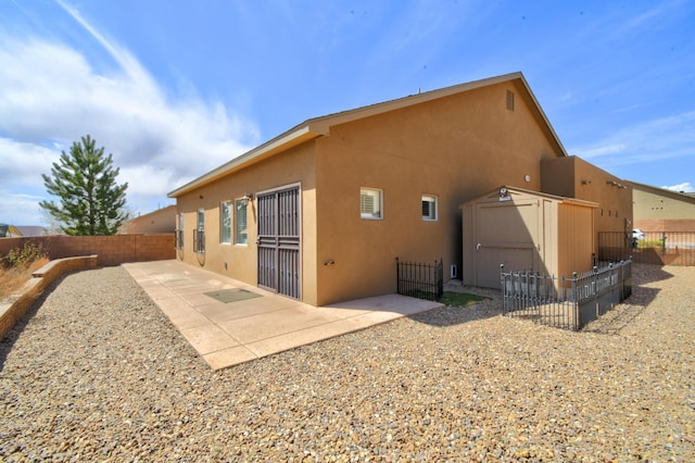 10916 Calandrias St NW, Albuquerque, NM 87114 - rear view of property with a fenced backyard, stucco siding, and a patio area