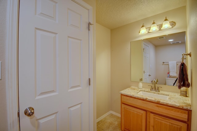 10916 Calandrias St NW, Albuquerque, NM 87114 - half bath featuring tile patterned flooring, vanity, toilet, a textured ceiling, and visible vents