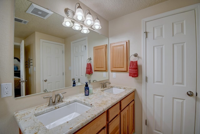 10916 Calandrias St NW, Albuquerque, NM 87114 - ensuite bathroom with visible vents, a sink, and a textured ceiling