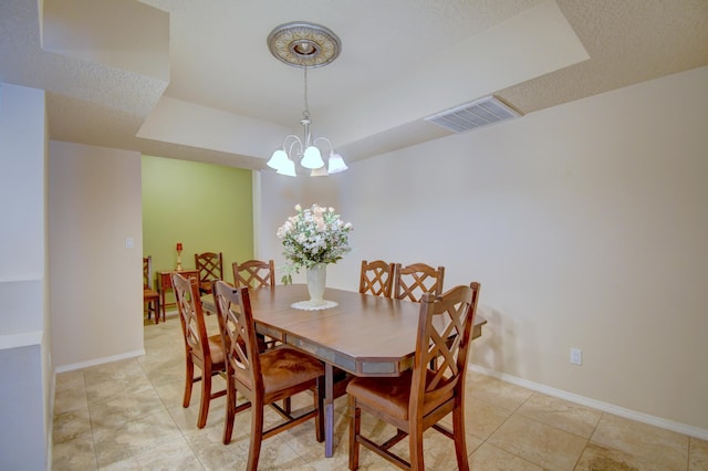 10916 Calandrias St NW, Albuquerque, NM 87114 - dining space featuring baseboards, a chandelier, a textured ceiling, a raised ceiling, and visible vents