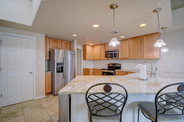 10916 Calandrias St NW, Albuquerque, NM 87114 - kitchen featuring a kitchen breakfast bar, a textured ceiling, light stone counters, a peninsula, and appliances with stainless steel finishes
