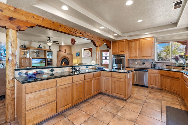 kitchen featuring plenty of natural light, a tray ceiling, a textured ceiling, and appliances with stainless steel finishes
