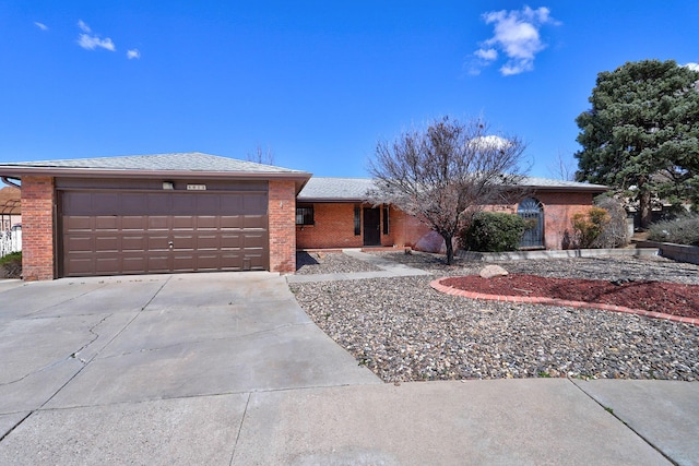 ranch-style home featuring an attached garage, brick siding, and concrete driveway