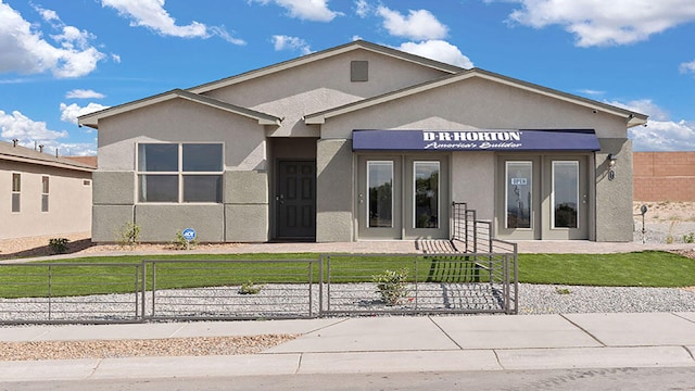 view of front facade featuring a fenced front yard, french doors, and stucco siding