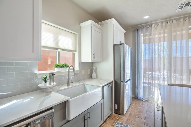 8717 Sevano Cir NE, Albuquerque, NM 87113 - kitchen with appliances with stainless steel finishes, wall chimney exhaust hood, a sink, light wood-style flooring, and recessed lighting