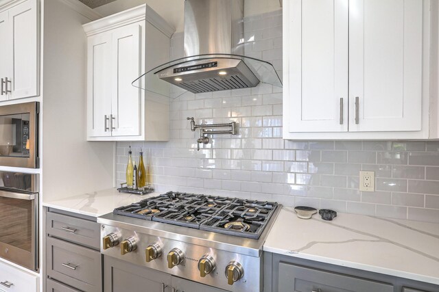 8717 Sevano Cir NE, Albuquerque, NM 87113 - kitchen featuring wall chimney exhaust hood, stainless steel gas stovetop, decorative backsplash, a ceiling fan, and a kitchen island