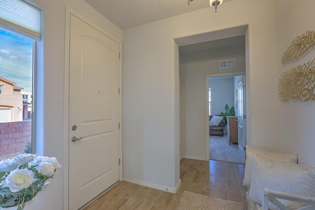 8717 Sevano Cir NE, Albuquerque, NM 87113 - kitchen with appliances with stainless steel finishes, wall chimney range hood, decorative backsplash, light stone countertops, and white cabinetry