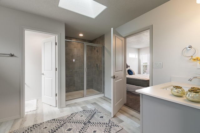9620 Sage Ranch Ct SW, Albuquerque, NM 87121 - full bathroom featuring wood finished floors, vanity, a shower stall, ensuite bathroom, and a skylight