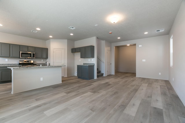 9600 Sage Ranch Ct SW, Albuquerque, NM 87121 - kitchen with appliances with stainless steel finishes, gray cabinetry, recessed lighting, light wood-style floors, and light stone counters