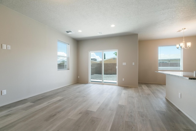 9600 Sage Ranch Ct SW, Albuquerque, NM 87121 - empty room with a textured ceiling, a chandelier, light wood-style flooring, and recessed lighting