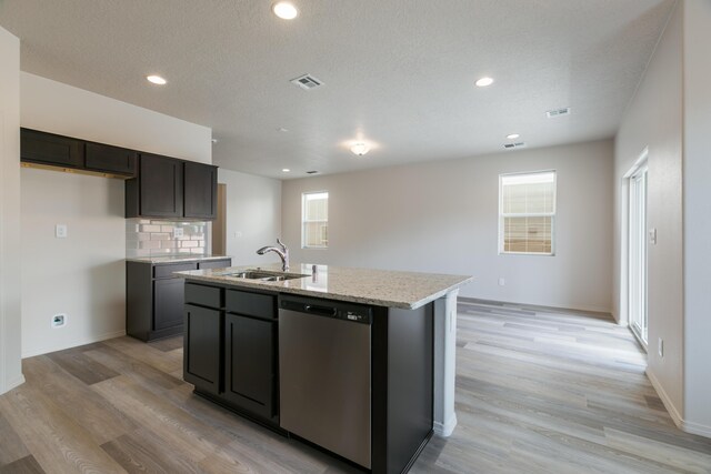 9504 Sage Ranch Ct SW, Albuquerque, NM 87121 - kitchen featuring dishwasher, light wood-type flooring, a kitchen island with sink, light stone counters, and recessed lighting