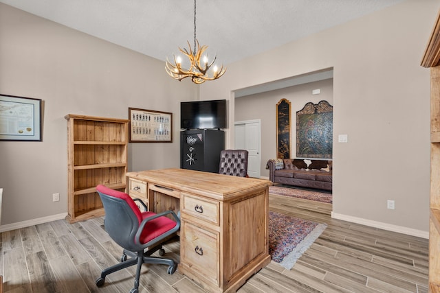 460 Rio Chama Cir SW, Los Lunas, NM 87031 - office featuring light wood-style floors, a chandelier, baseboards, and a textured ceiling