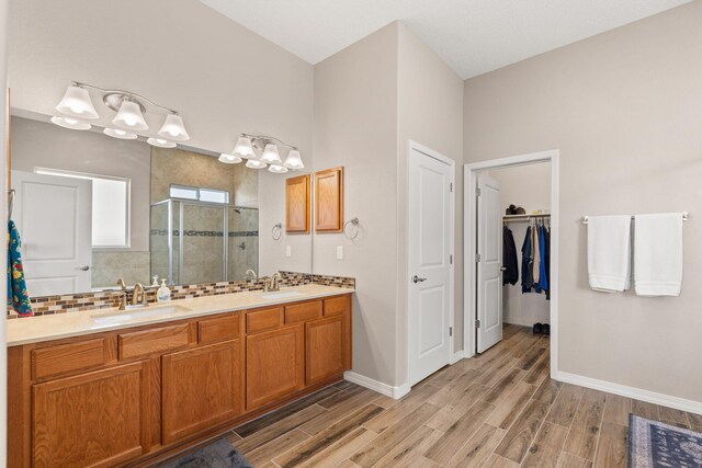 460 Rio Chama Cir SW, Los Lunas, NM 87031 - bathroom with a shower stall, double vanity, wood finished floors, and baseboards