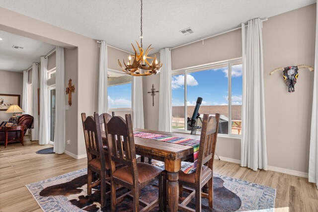 460 Rio Chama Cir SW, Los Lunas, NM 87031 - dining space featuring a chandelier, light wood-style flooring, and baseboards