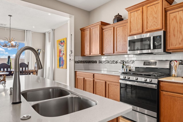 460 Rio Chama Cir SW, Los Lunas, NM 87031 - kitchen with stainless steel appliances, a sink, decorative backsplash, a chandelier, and recessed lighting