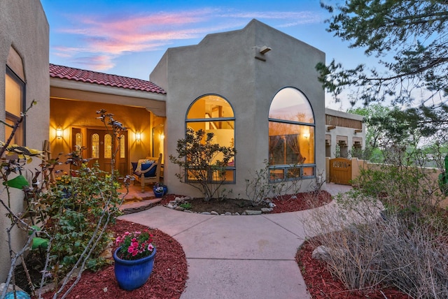 1125 Marigold Dr NE, Albuquerque, NM 87122 - rear view of property featuring a tile roof, fence, stucco siding, and a gate