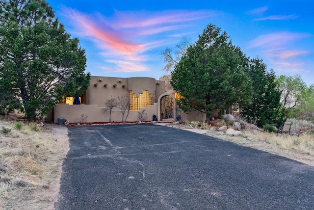 1125 Marigold Dr NE, Albuquerque, NM 87122 - pueblo-style house featuring fence private yard, stucco siding, and a gate