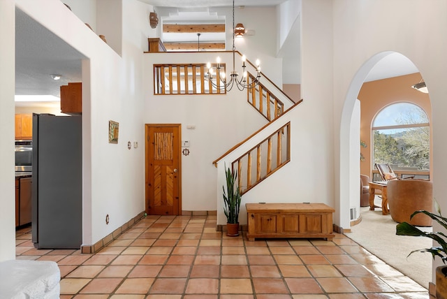 1125 Marigold Dr NE, Albuquerque, NM 87122 - foyer entrance featuring baseboards, arched walkways, stairs, and a high ceiling