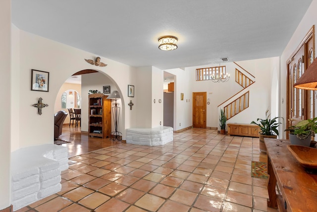 1125 Marigold Dr NE, Albuquerque, NM 87122 - entrance foyer featuring an inviting chandelier, stairway, and arched walkways